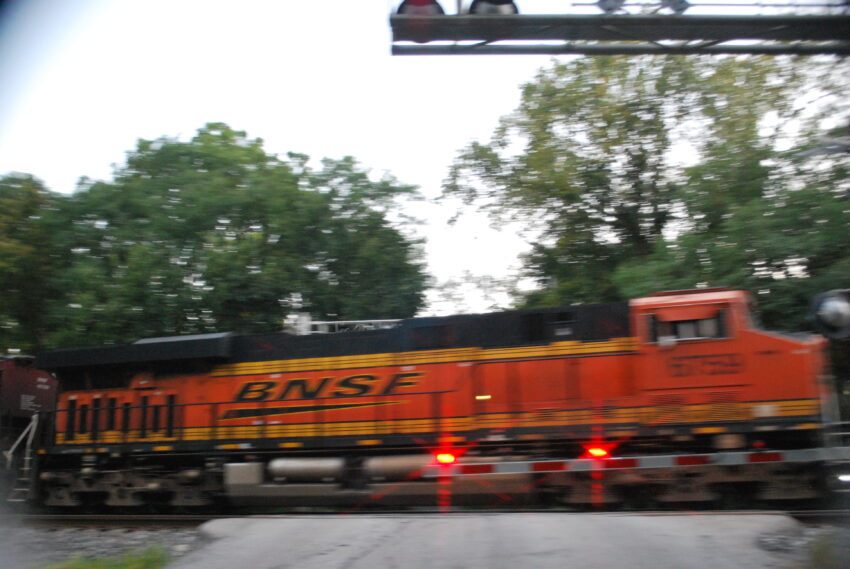 An eastbound BNSF train rushes through a crossing on CSX's Garrett Line in Indiana